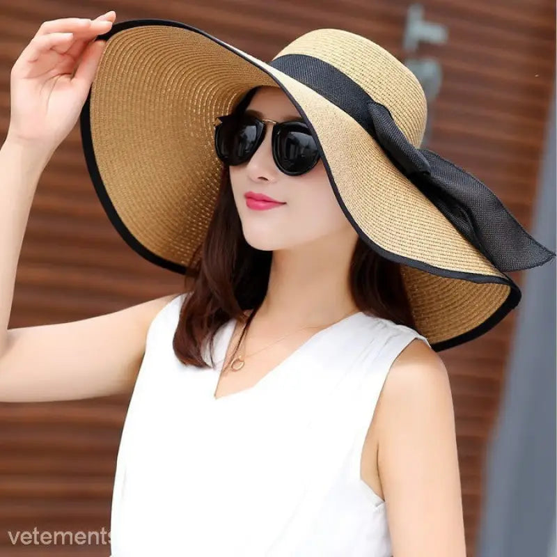 Wide-brimmed straw sun hat with black ribbon band in navy blue solid featuring blue gypsophila accents