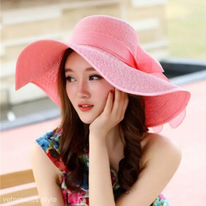 Pink wide-brimmed sun hat worn by a woman from Satin Lace Straw Hat in Navy Blue Solid