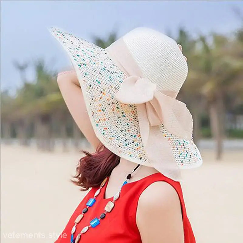 Wide-brimmed sun hat in navy blue solid with colorful speckles and cream ribbon