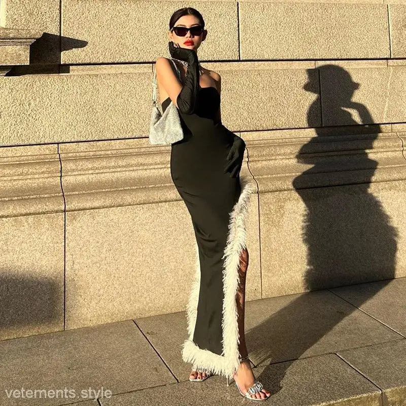 Woman in a sleek black Maxi Dress with high grade fur stitching and sunglasses outdoors