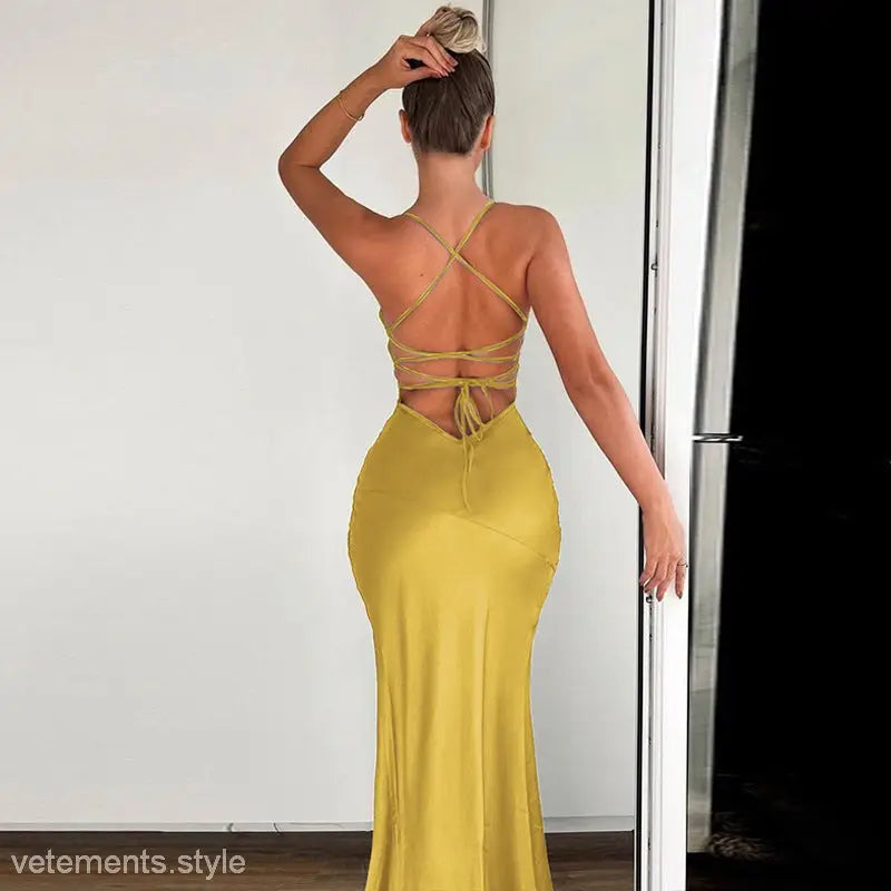 Yellow backless dress with criss-cross straps and form-fitting silhouette for summer events