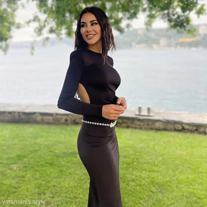 Woman in a form-fitting black backless maxi dress with rhinestones for parties