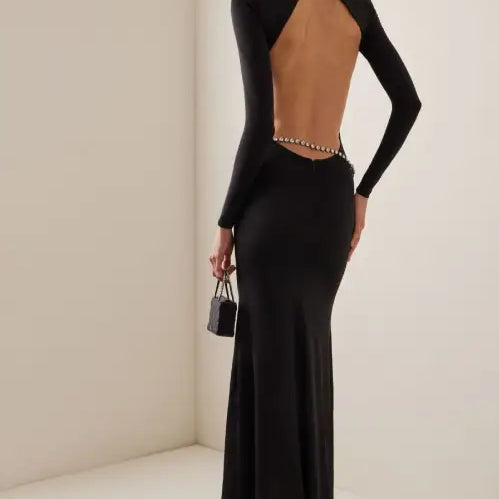 Elegant long black evening gown featuring a jeweled waist and an open back, perfect for parties