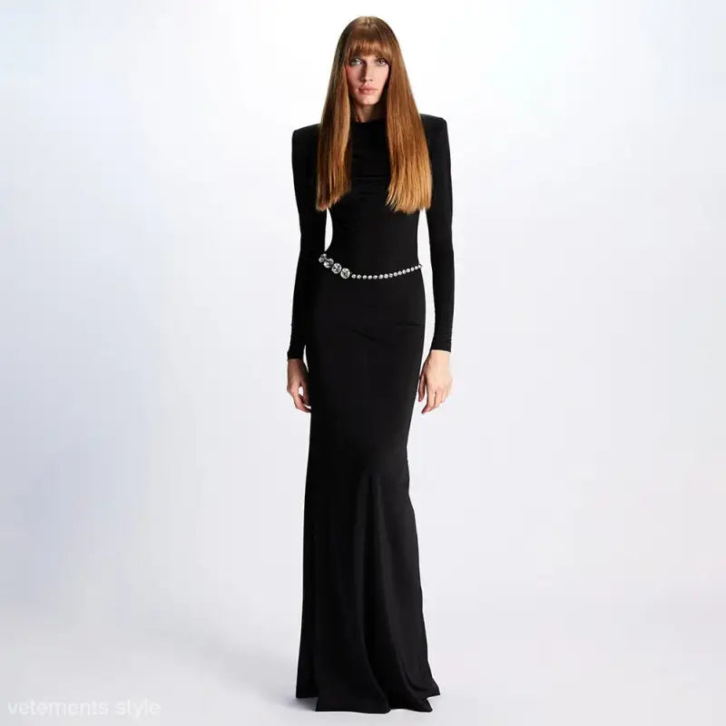 Elegant backless maxi dress features long sleeves and a silver chain belt for parties