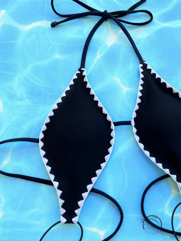 Sexy black halter bikini top with white zigzag trim on blue background, free shipping