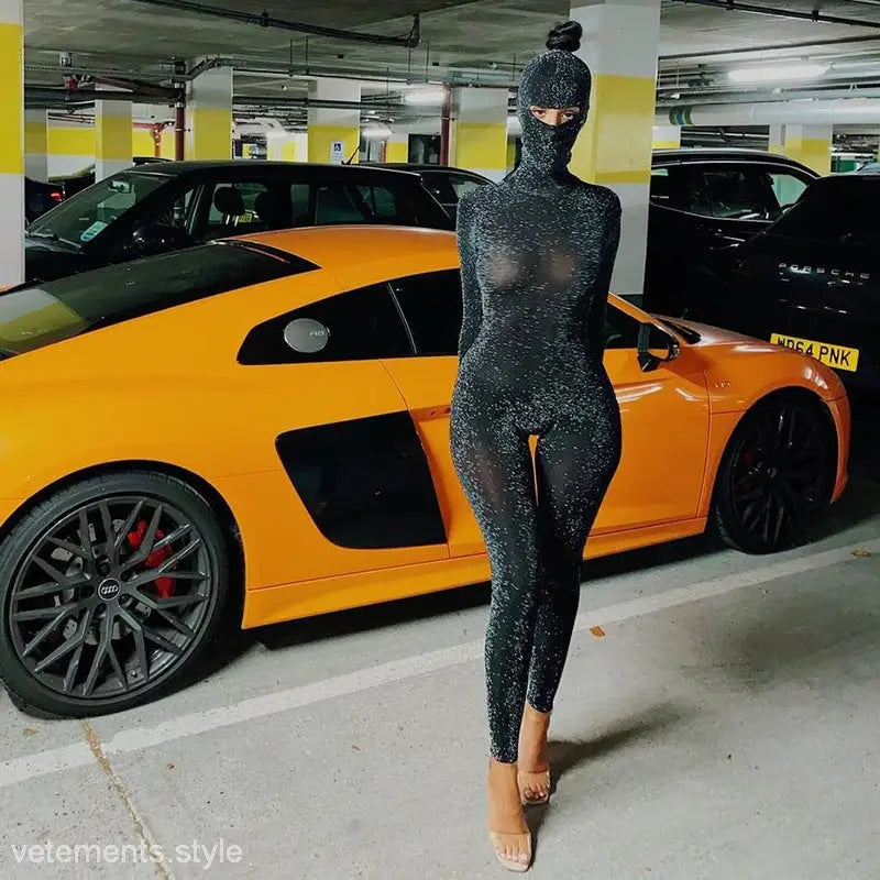 Sexy Catwoman jumpsuit with cutout design and heels beside bright orange sports car