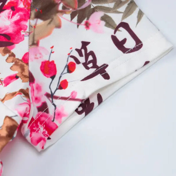 Floral-patterned fabric with pink blossoms and Japanese calligraphy.