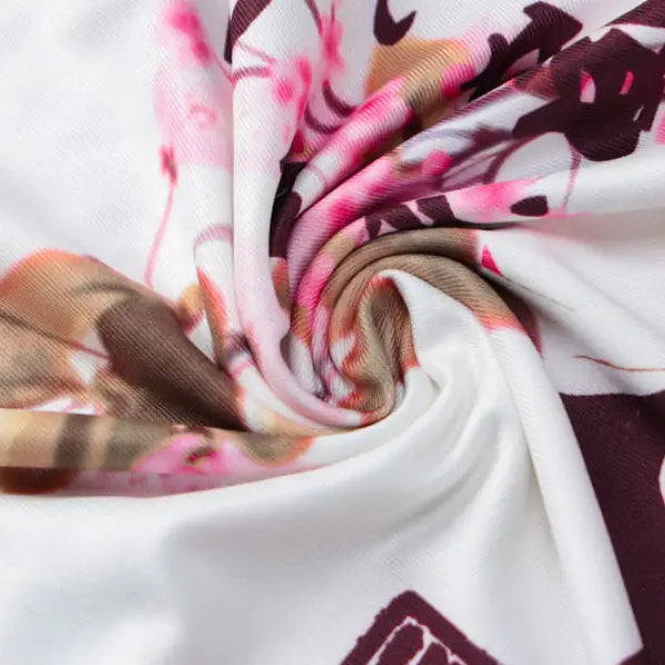 Swirled fabric with a floral pattern in pink, burgundy, and white tones.
