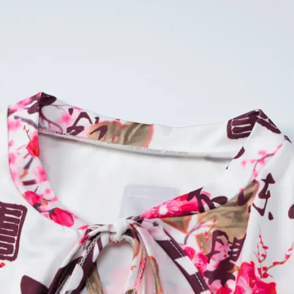 Floral and calligraphy-patterned fabric garment with a tied neckline.