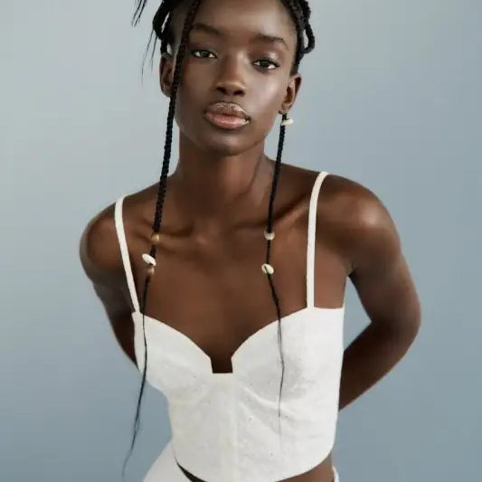 Woman in white crop top and skirt showcasing French Niche Hollow Cutout design