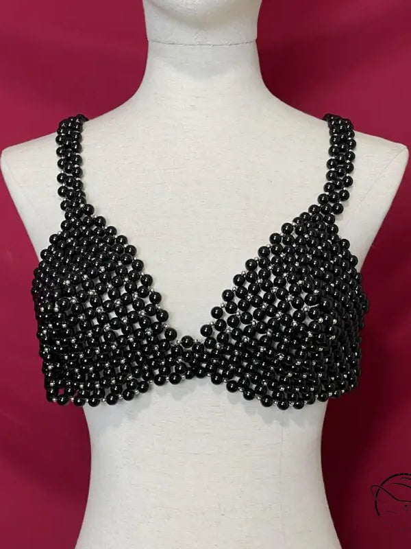 Black beaded bralette on mannequin showcasing handmade pearl bra for summer wear