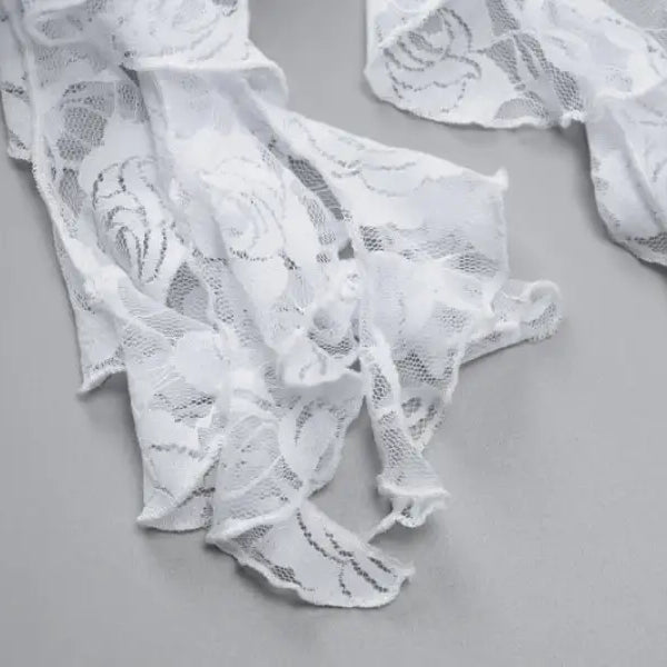Torn or shredded pieces of white lace fabric.