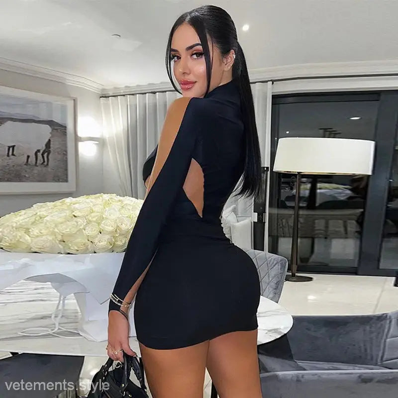 A form-fitting black mesh slim fit dress with long sleeves and an open back design