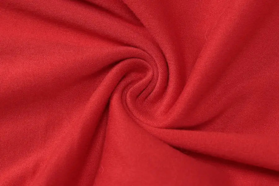 Red fabric with a swirling pattern showcasing the sexy metal buckle in a buckle yoga jumpsuit