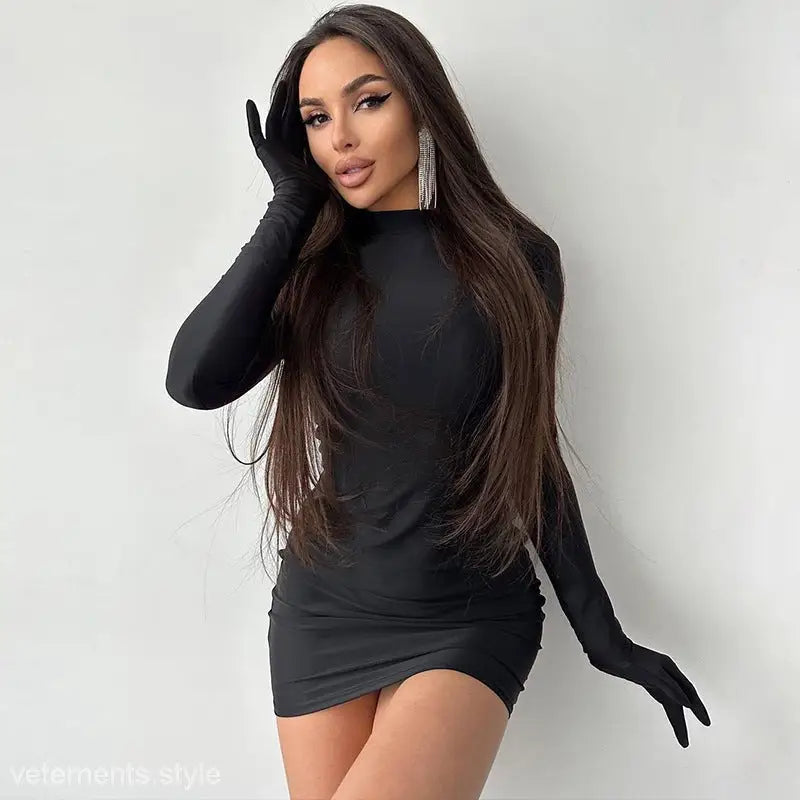 Woman in a sexy sheath long party bodycon dress and long sleeve gloves against white background