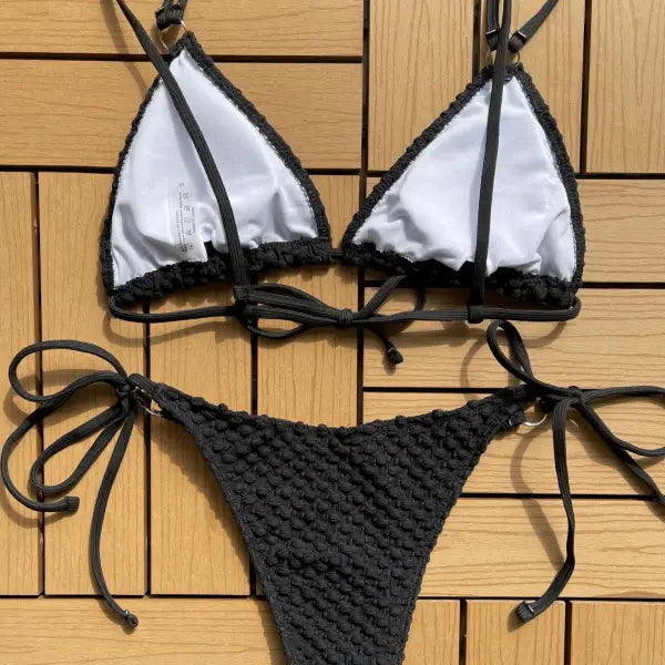 Bikini with a white triangle top and black crochet-style bottom.