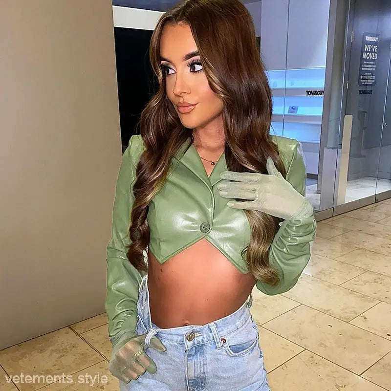 Woman in green crop top and jeans wearing a slim faux leather jacket for spring and fall