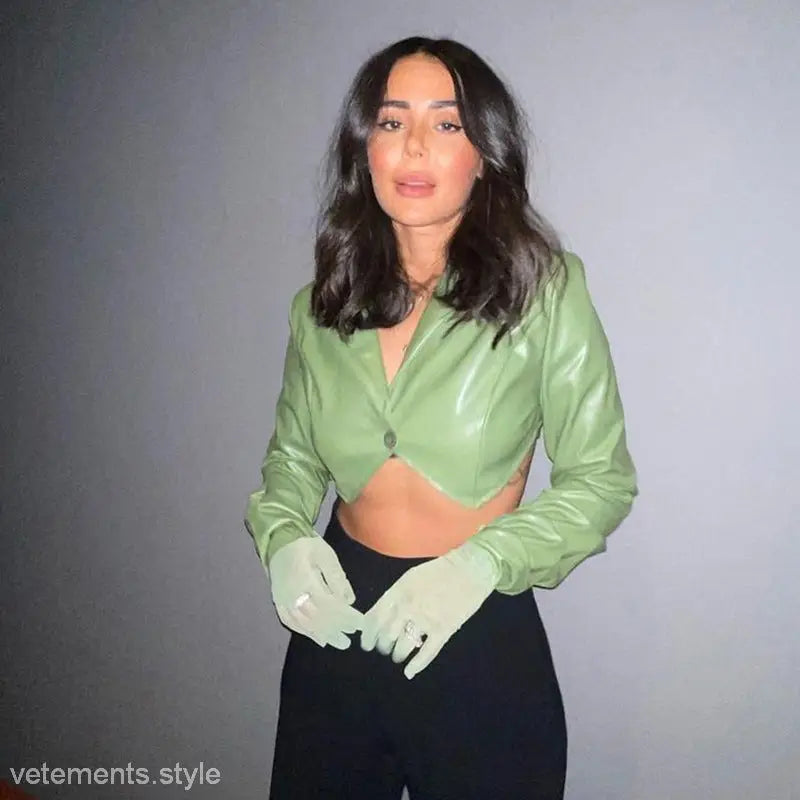 Woman in green crop top and gloves wearing stylish slim faux leather jacket for spring and fall wear