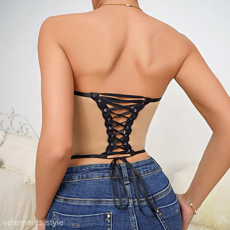 Slim fit corset tube top with lace and cutout design on a woman’s bare back over blue jeans