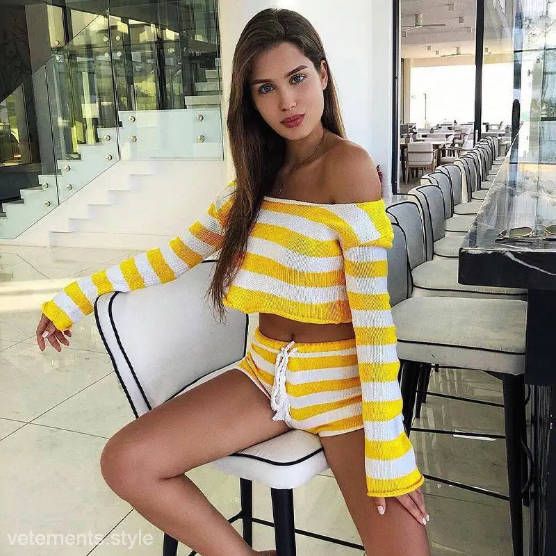 Woman wearing a yellow and white striped off-the-shoulder top with matching sexy knitted striped shorts