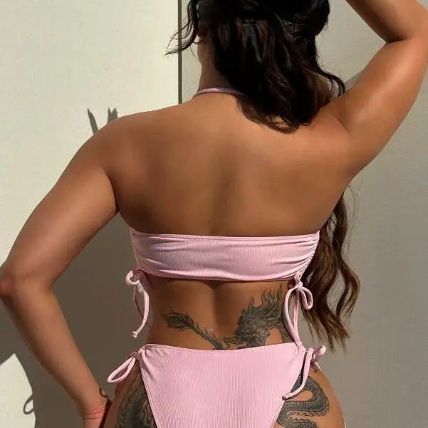 Woman in sexy tied swimsuit with pink bikini and dragon tattoo on back