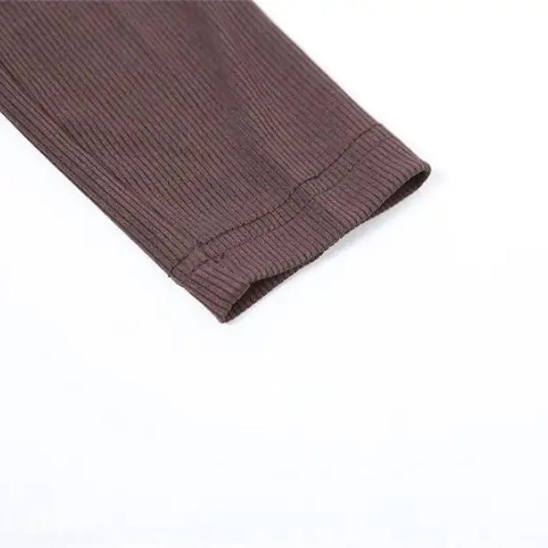 Detail of brown ribbed knit sweater sleeve with folded cuff on sexy yoga long jumpsuit