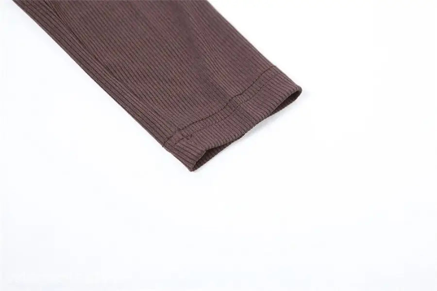 Detail of brown ribbed knit sweater sleeve with folded cuff on sexy yoga long jumpsuit