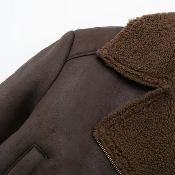 Brown leather jacket with fuzzy collar and visible zipper, featuring fleece short stitching