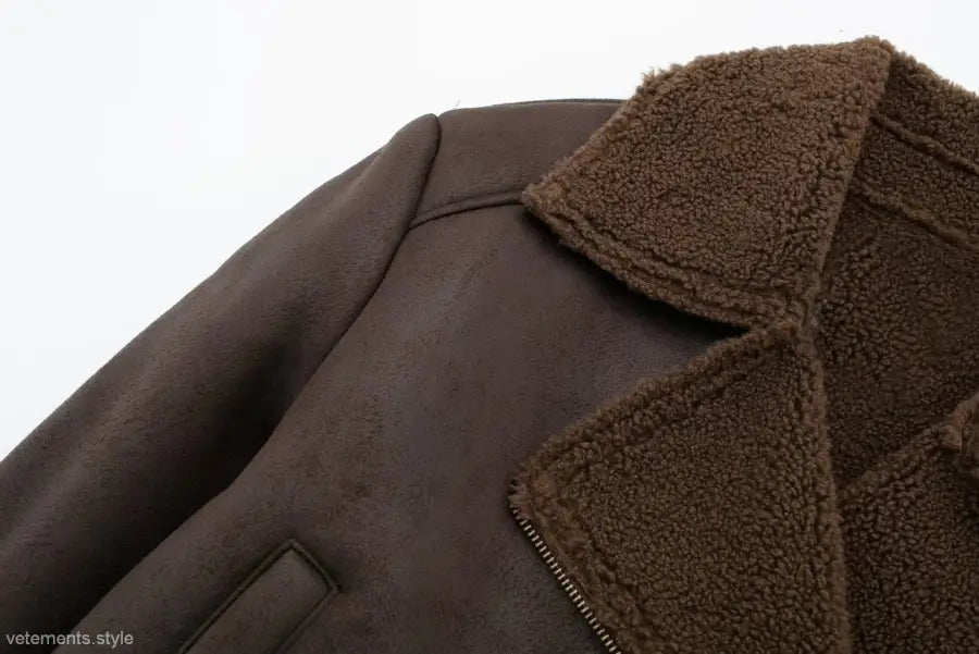 Brown leather jacket with fuzzy collar and visible zipper, featuring fleece short stitching