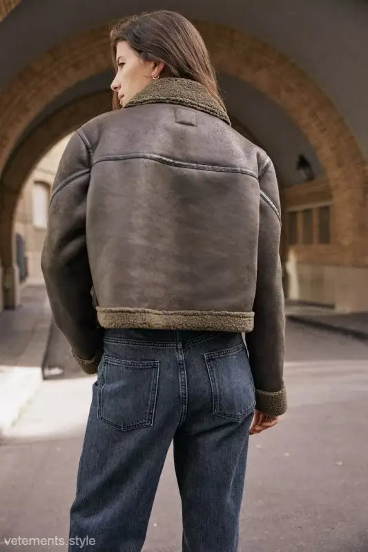 Shearling-lined leather jacket with fleece short stitching, paired with blue jeans