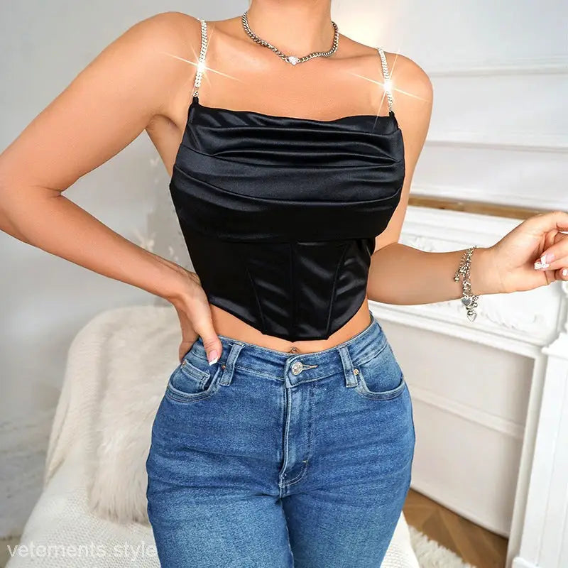 Black satin crop top with rhinestone straps, featuring shiny black boning for a slimming look