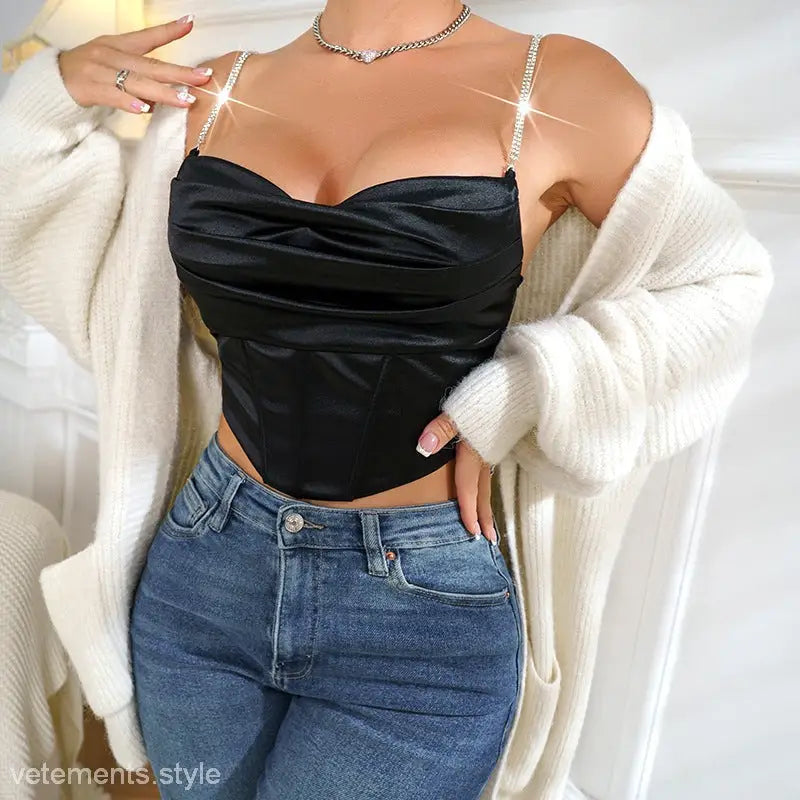 Model showcases shiny black boning crop top with rhinestones paired with blue jeans