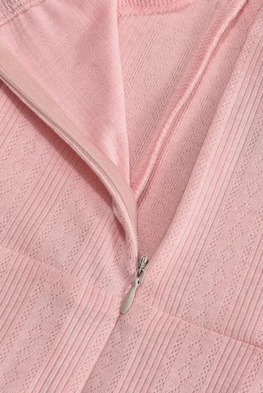 Pink textured fabric with a partially visible zipper.