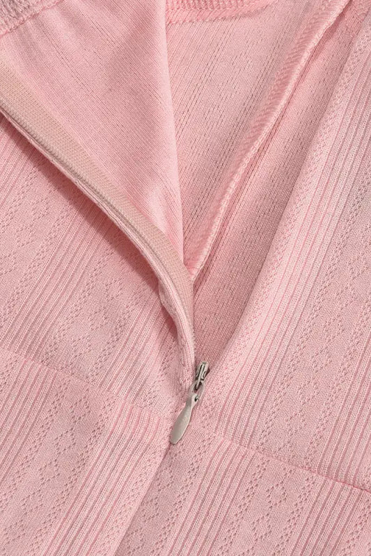 Pink textured fabric with a partially visible zipper.
