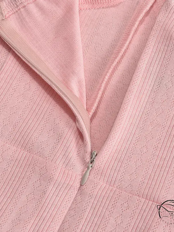 Pink textured fabric with a partially visible zipper.