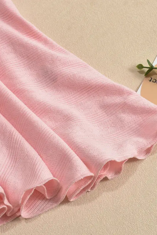Soft pink fabric with delicate folds and a subtle pattern.