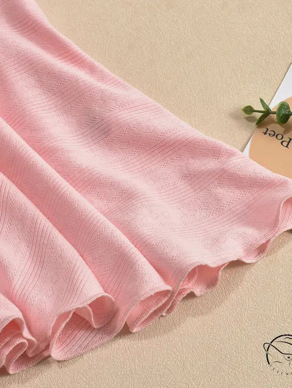 Soft pink fabric with delicate folds and a subtle pattern.