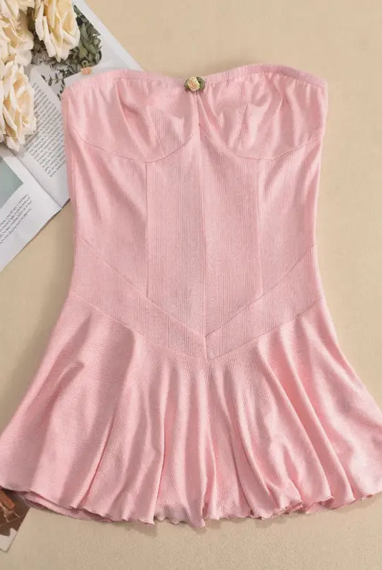 Pink strapless dress with a fitted bodice and flared skirt.