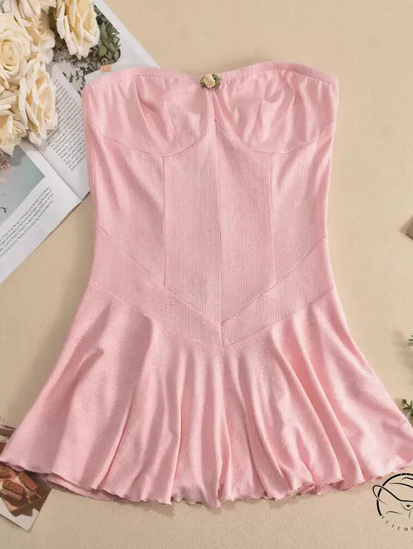 Pink strapless dress with a fitted bodice and flared skirt.