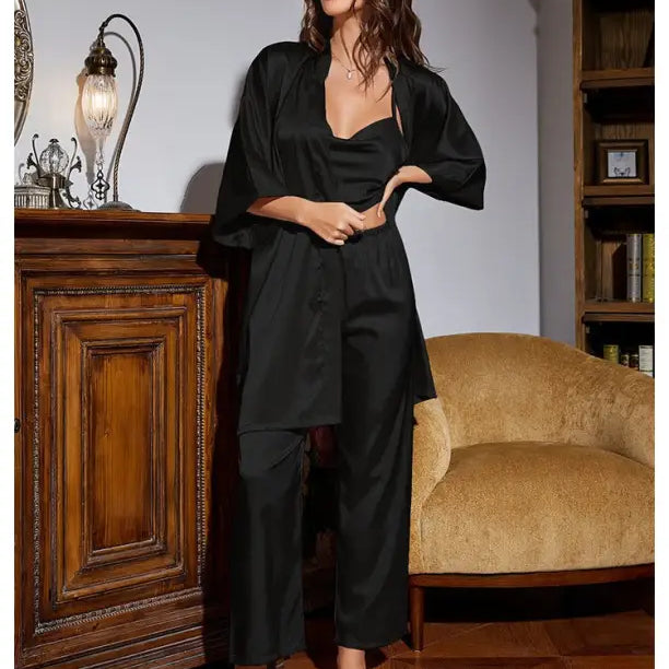 Woman in black silk home wear lounge set featuring a wide-legged jumpsuit and matching robe