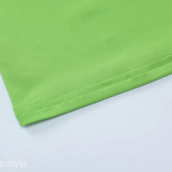 Green fabric hem detail of Slim Polyester Crop Top in stylish shorts suit ensemble