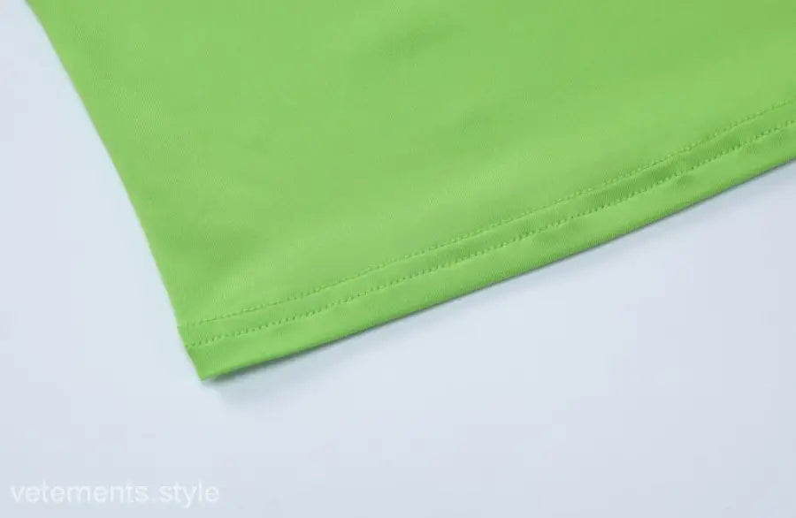 Green fabric hem detail of Slim Polyester Crop Top in stylish shorts suit ensemble