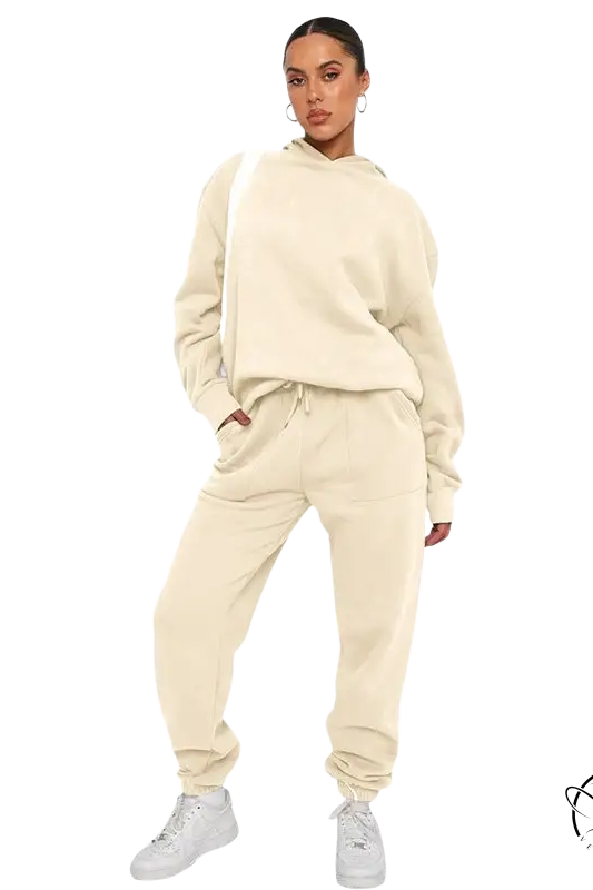 Woman in cream sweatsuit and white sneakers, soft touch trousers with warm comfortable long sleeve sweater