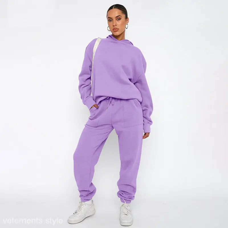 Woman wearing lavender soft touch trousers and warm comfortable long sleeve sweater with white sneakers