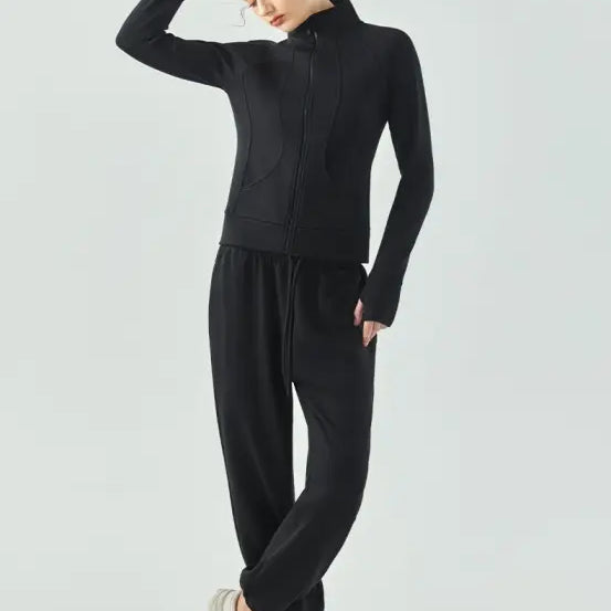 Woman in black athletic outfit with loose pants and white sneakers wearing linen green air layer coat