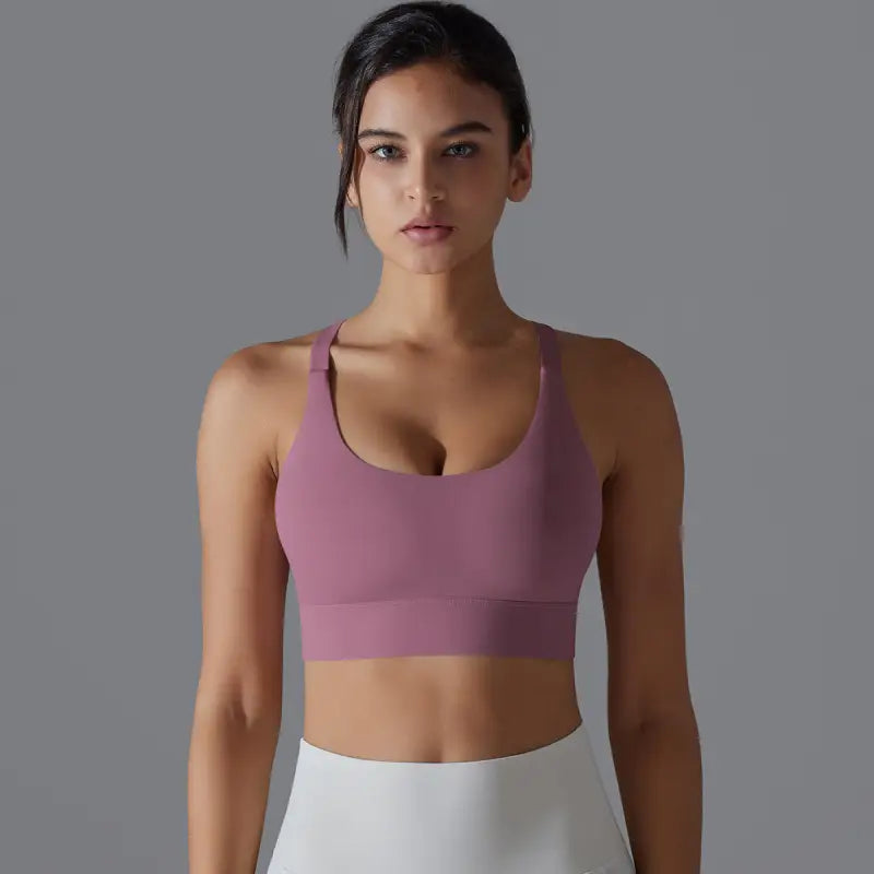 Pink sports bra worn by a woman showcasing the backless yoga vest with cutout design