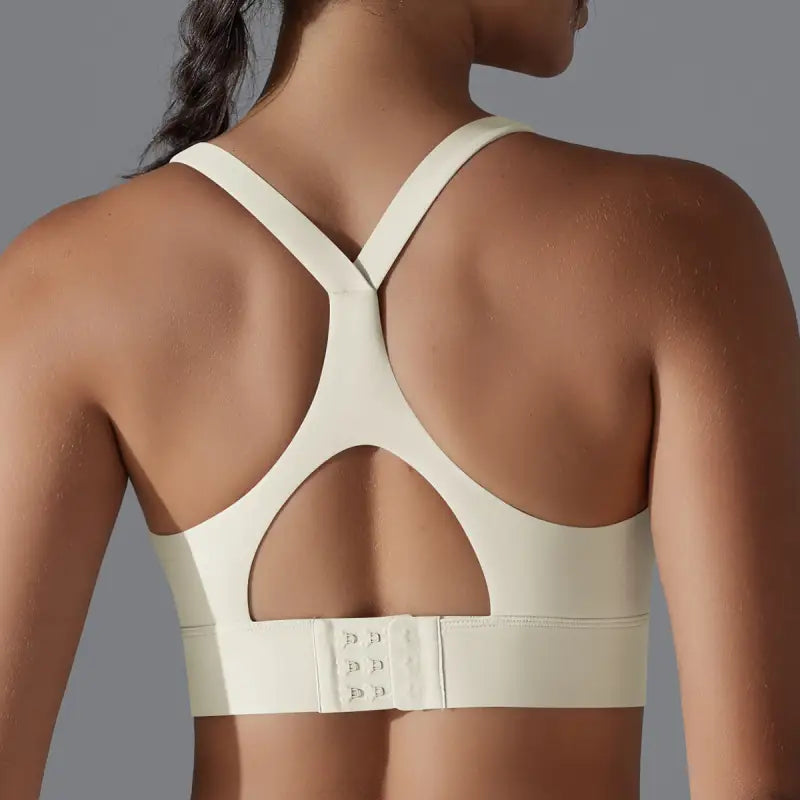 White sports bra with racerback design and hook closure, ideal for backless yoga vest activities