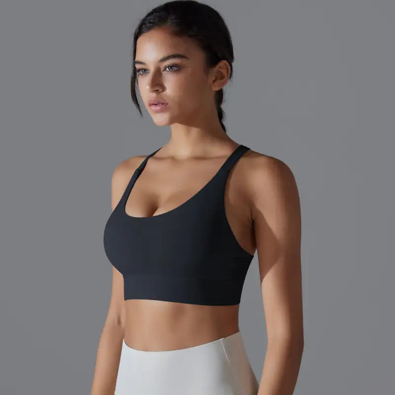 Woman wearing a black backless yoga vest with cutout back and crossback design