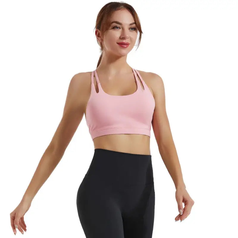 Woman in pink sports bra and black leggings showcasing the Fitness Bra in Hydrangea Purple