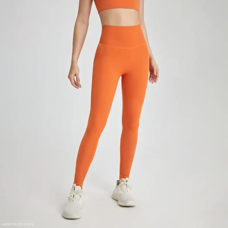 Wild berry color sporty high-rise nylon pants with orange leggings and white sneakers